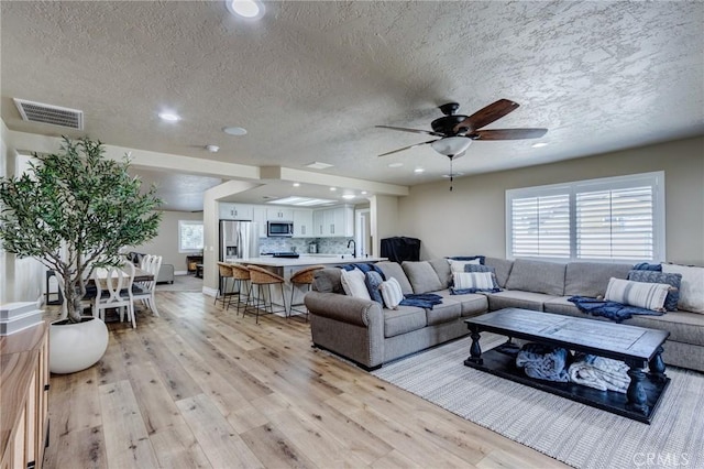 7434 Paisley Ave, Hesperia, CA 92345 - living room with ceiling fan, light wood finished floors, a textured ceiling, and recessed lighting