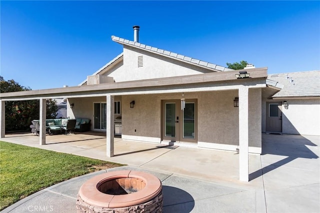 7434 Paisley Ave, Hesperia, CA 92345 - back of property with stucco siding, a patio area, an outdoor living space with a fire pit, and a lawn