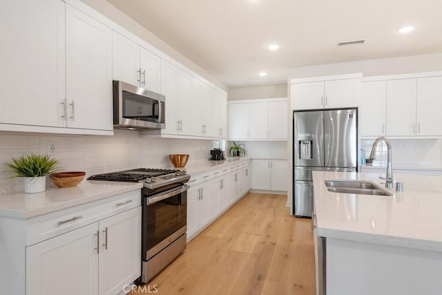 4835 S Cora Way, Ontario, CA 91762 - kitchen with appliances with stainless steel finishes, backsplash, white cabinets, and recessed lighting