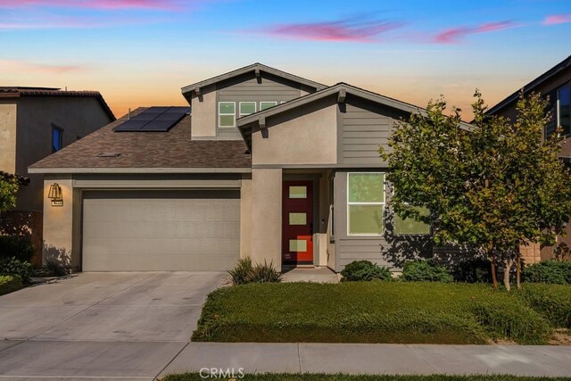 4835 S Cora Way, Ontario, CA 91762 - view of front of property featuring solar panels, driveway, a garage, roof with shingles, and stucco siding