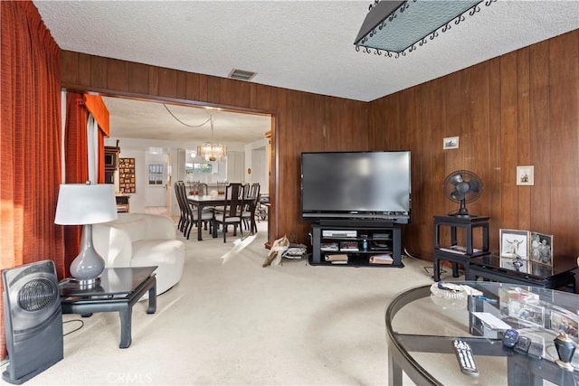 16401 Gothic Pl, Granada Hills, CA 91344 - carpeted living room with wood walls, a chandelier, and a textured ceiling