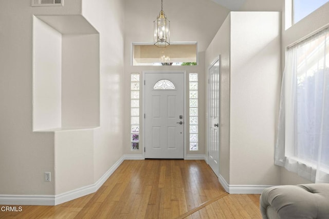 7748 Paso Robles St, Ventura, CA 93004 - foyer featuring wood-type flooring, plenty of natural light, and a chandelier