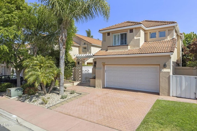 7748 Paso Robles St, Ventura, CA 93004 - mediterranean / spanish-style home featuring stucco siding, a tiled roof, decorative driveway, an attached garage, and a gate