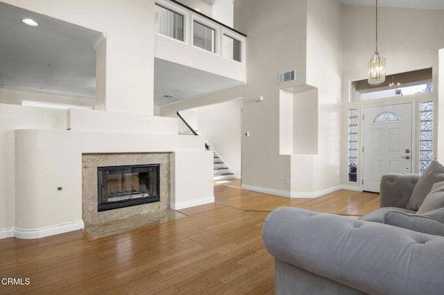 7748 Paso Robles St, Ventura, CA 93004 - living room with a high ceiling, wood finished floors, stairs, a chandelier, and a high end fireplace