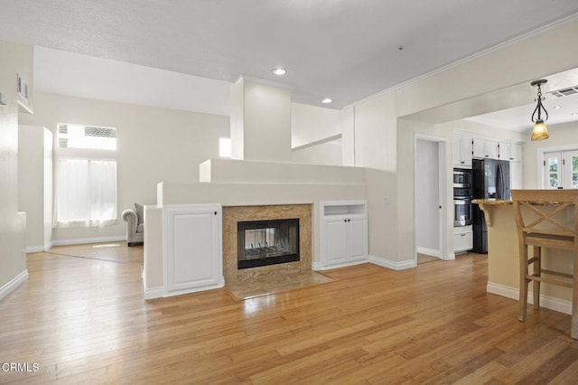 7748 Paso Robles St, Ventura, CA 93004 - unfurnished living room featuring light wood finished floors, recessed lighting, a tiled fireplace, and crown molding