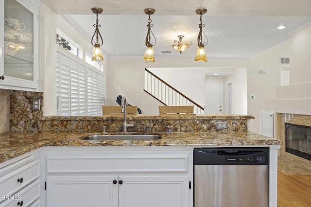 7748 Paso Robles St, Ventura, CA 93004 - kitchen with stainless steel dishwasher, white cabinets, decorative backsplash, stone counters, and light wood-style floors