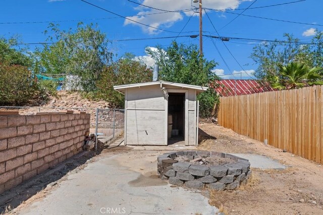 15722 Inyo St, Victorville, CA 92395 - fenced backyard with a shed and an outdoor fire pit