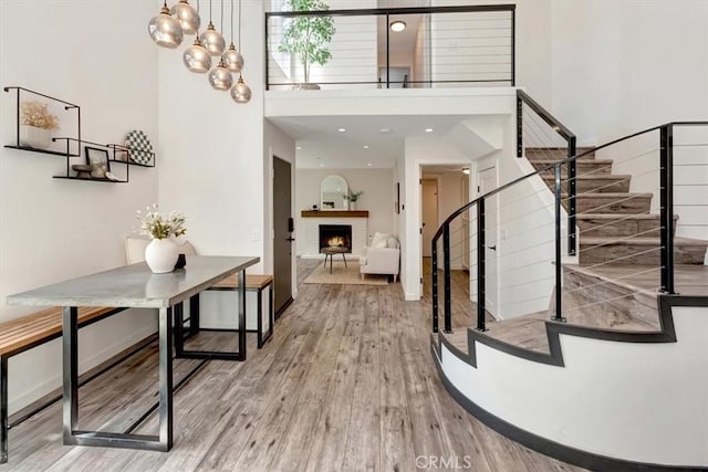 3010 Rosalinda Unit 50, San Clemente, CA 92673 - entrance foyer with stairs, wood finished floors, a high ceiling, and a lit fireplace