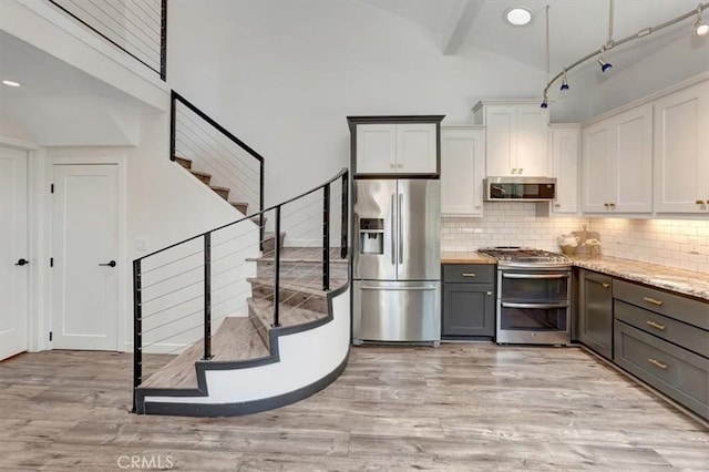 3010 Rosalinda Unit 50, San Clemente, CA 92673 - kitchen featuring appliances with stainless steel finishes, gray cabinets, light wood-style flooring, decorative backsplash, and beamed ceiling