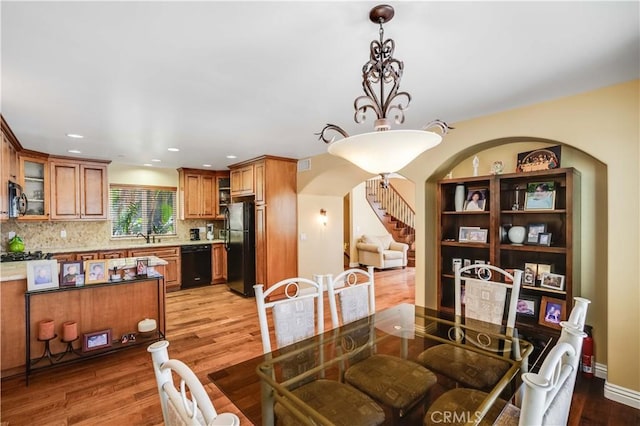 21460 Arapahoe Trl, Chatsworth, CA 91311 - dining area with arched walkways, light wood-style floors, recessed lighting, and stairs