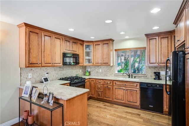 21460 Arapahoe Trl, Chatsworth, CA 91311 - kitchen with black appliances, a peninsula, brown cabinets, light wood-style flooring, and recessed lighting