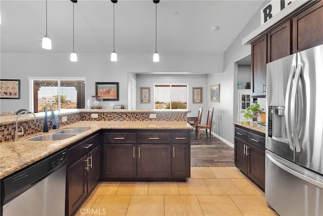 9512 Mesquite St, Phelan, CA 92371 - kitchen featuring appliances with stainless steel finishes, dark brown cabinets, light stone countertops, hanging light fixtures, and plenty of natural light