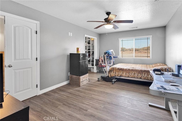 9512 Mesquite St, Phelan, CA 92371 - bedroom with wood finished floors, ceiling fan, and a textured ceiling