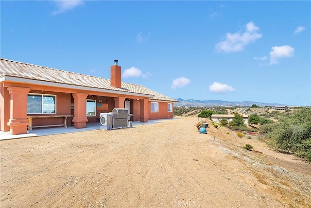 9512 Mesquite St, Phelan, CA 92371 - rear view of property featuring a patio area, a chimney, and a mountain view