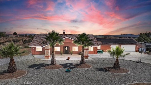 9512 Mesquite St, Phelan, CA 92371 - view of front of house with roof mounted solar panels, a tiled roof, a chimney, and driveway
