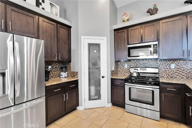 9512 Mesquite St, Phelan, CA 92371 - kitchen featuring stainless steel appliances, dark brown cabinets, backsplash, light tile patterned floors, and light stone countertops