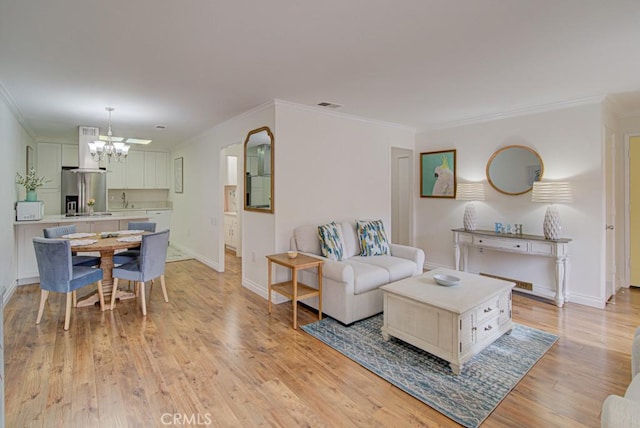 3130 Via Serena N Unit B, Laguna Woods, CA 92637 - living room featuring a chandelier, ornamental molding, and light wood-style flooring