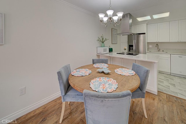 3130 Via Serena N Unit B, Laguna Woods, CA 92637 - dining room featuring a chandelier, light wood-style floors, ornamental molding, and a skylight