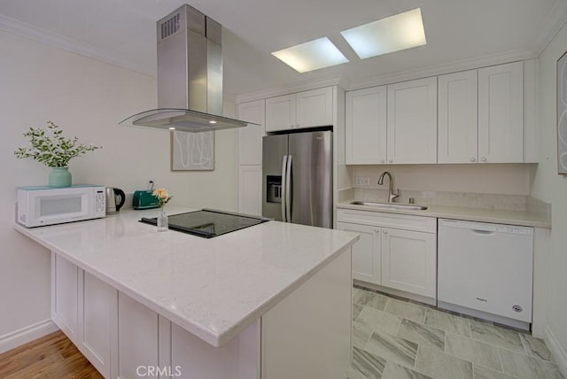 3130 Via Serena N Unit B, Laguna Woods, CA 92637 - kitchen featuring white appliances, island exhaust hood, a peninsula, white cabinets, and ornamental molding