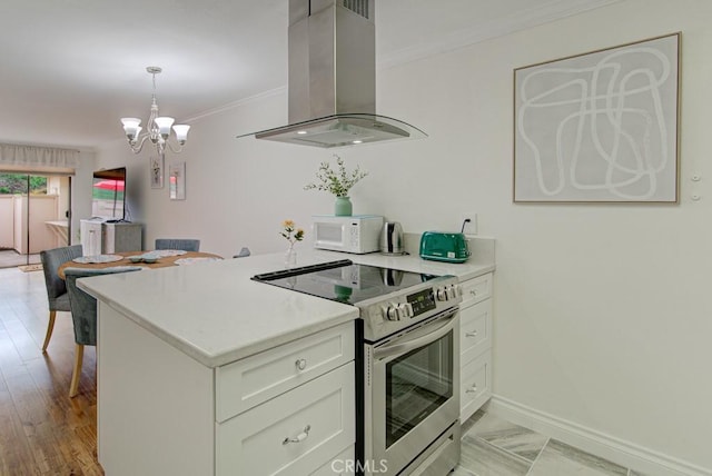 3130 Via Serena N Unit B, Laguna Woods, CA 92637 - kitchen featuring stainless steel range with electric cooktop, island range hood, white microwave, a chandelier, and ornamental molding