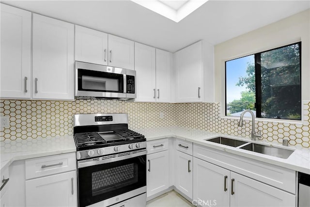 2473 Oswego St Unit 17, Pasadena, CA 91107 - kitchen with appliances with stainless steel finishes, white cabinetry, backsplash, and light stone counters