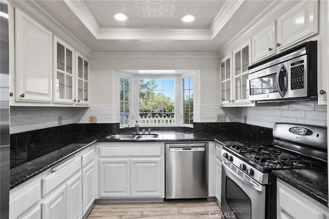 2720 Hilltop Dr Unit 58, Newport Beach, CA 92660 - kitchen featuring stainless steel appliances, white cabinetry, a raised ceiling, backsplash, and dark stone counters