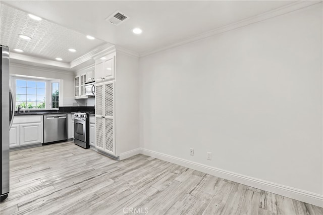 2720 Hilltop Dr Unit 58, Newport Beach, CA 92660 - kitchen featuring appliances with stainless steel finishes, dark countertops, light wood-type flooring, crown molding, and white cabinetry
