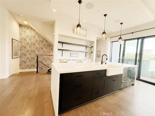 753 Site Dr, Brea, CA 92821 - kitchen with light wood-style flooring, light countertops, a center island with sink, open shelves, and hanging light fixtures