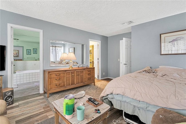 19428 Shasta Rd, Apple Valley, CA 92307 - bedroom with light wood-style flooring, ensuite bathroom, and a textured ceiling