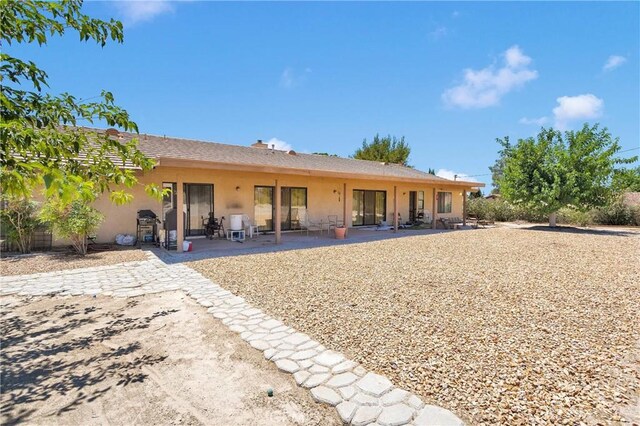 19428 Shasta Rd, Apple Valley, CA 92307 - back of house with stucco siding and a patio