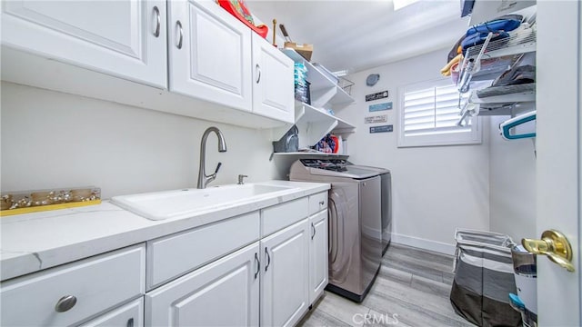 18223 Shannon Ridge Pl, Canyon Country, CA 91387 - laundry room with washing machine and clothes dryer, cabinet space, and light wood-style floors