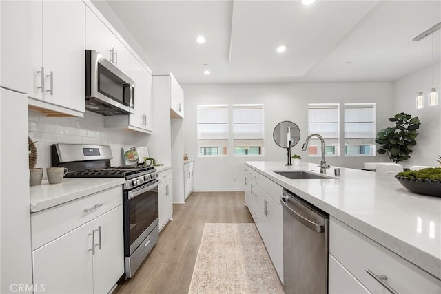 426 W Central Ave, Brea, CA 92821 - kitchen featuring appliances with stainless steel finishes, light countertops, white cabinetry, backsplash, and light wood-type flooring