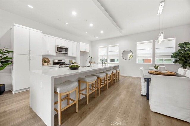 426 W Central Ave, Brea, CA 92821 - kitchen with stainless steel appliances, light wood-type flooring, white cabinetry, a kitchen island with sink, and recessed lighting