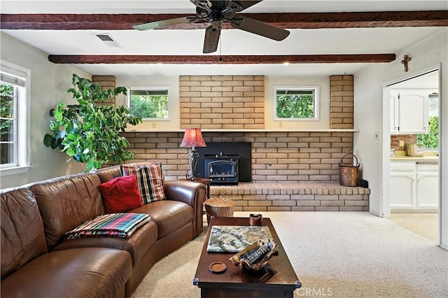 2997 June Ct, Merced, CA 95348 - living room with plenty of natural light, beamed ceiling, a wood stove, ceiling fan, and carpet