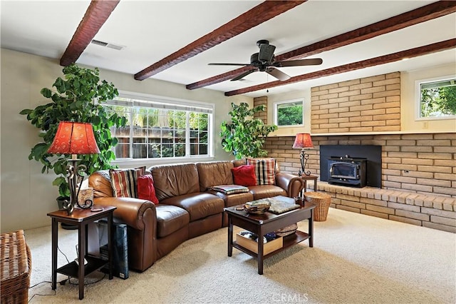 2997 June Ct, Merced, CA 95348 - living area with a wood stove, carpet flooring, beamed ceiling, plenty of natural light, and ceiling fan