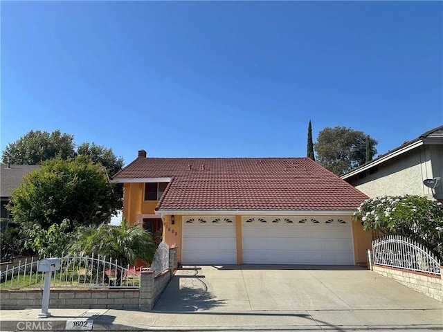 1602 Via Palermo, Montebello, CA 90640 - view of front of home with a tile roof, an attached garage, concrete driveway, and stucco siding