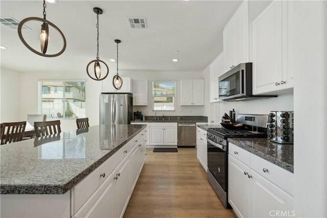 36300 Firelight Cir, Wildomar, CA 92595 - kitchen featuring appliances with stainless steel finishes, recessed lighting, a center island, white cabinetry, and light wood finished floors