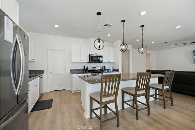36300 Firelight Cir, Wildomar, CA 92595 - kitchen featuring stainless steel appliances, a kitchen island, a kitchen breakfast bar, recessed lighting, and white cabinetry