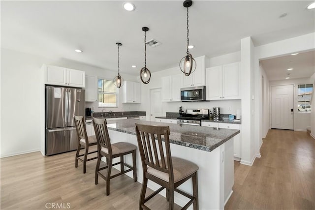 36300 Firelight Cir, Wildomar, CA 92595 - kitchen with stainless steel appliances, a kitchen island, a kitchen bar, white cabinets, and recessed lighting