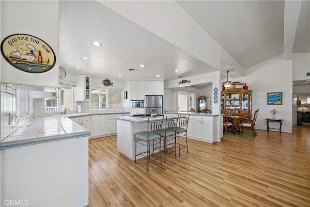 6536 Oceanview Dr Unit T, Carlsbad, CA 92011 - kitchen with stainless steel appliances, a breakfast bar area, light wood-type flooring, plenty of natural light, and recessed lighting
