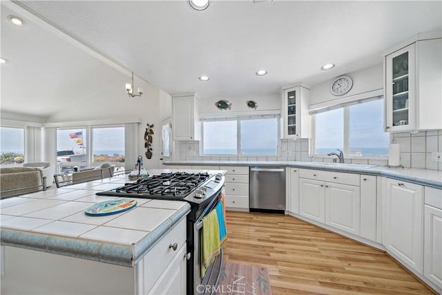 6536 Oceanview Dr Unit T, Carlsbad, CA 92011 - kitchen with appliances with stainless steel finishes, light wood-style flooring, white cabinets, tasteful backsplash, and recessed lighting