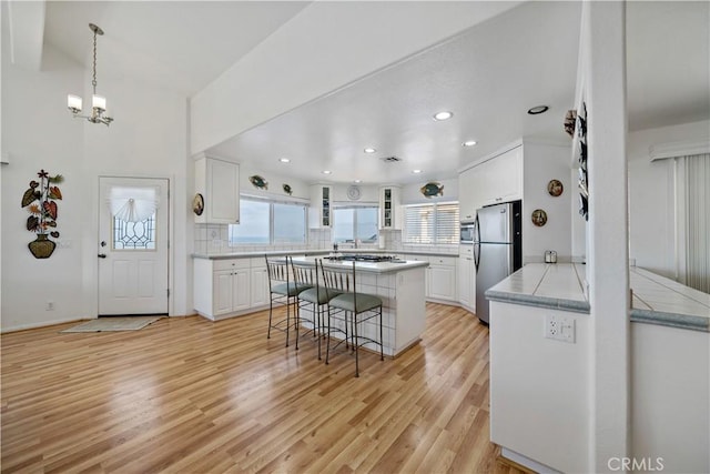 6536 Oceanview Dr Unit T, Carlsbad, CA 92011 - kitchen featuring stainless steel appliances, white cabinets, a kitchen island, decorative backsplash, and recessed lighting