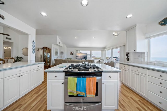 6536 Oceanview Dr Unit T, Carlsbad, CA 92011 - kitchen with stainless steel range with gas stovetop, light wood-style floors, open floor plan, light countertops, and white cabinets