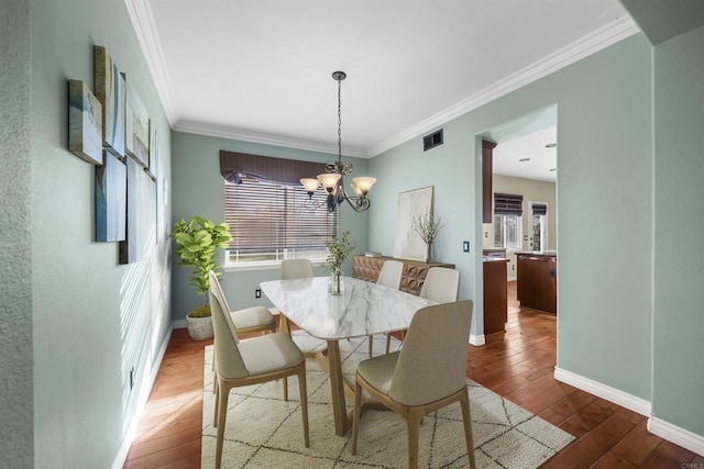 1033 Goldeneye, Carlsbad, CA 92011 - dining space with healthy amount of natural light, wood-type flooring, ornamental molding, and a chandelier