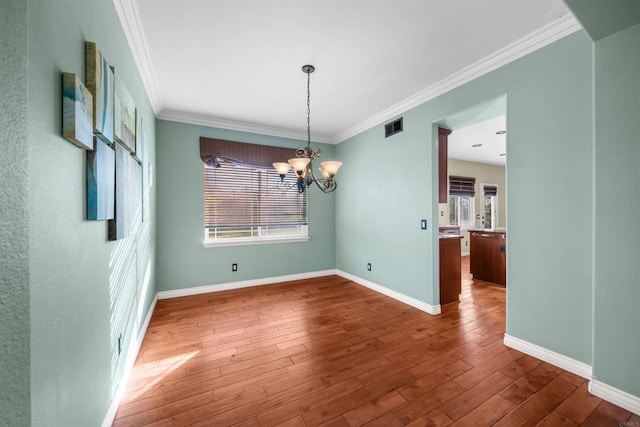 1033 Goldeneye, Carlsbad, CA 92011 - unfurnished dining area with plenty of natural light, ornamental molding, a chandelier, and wood finished floors