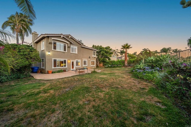 1033 Goldeneye, Carlsbad, CA 92011 - back of house at dusk with a patio, stucco siding, and a chimney