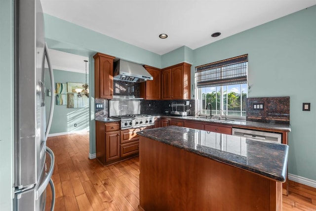 1033 Goldeneye, Carlsbad, CA 92011 - kitchen featuring stainless steel appliances, wall chimney exhaust hood, light wood-style flooring, tasteful backsplash, and a kitchen island