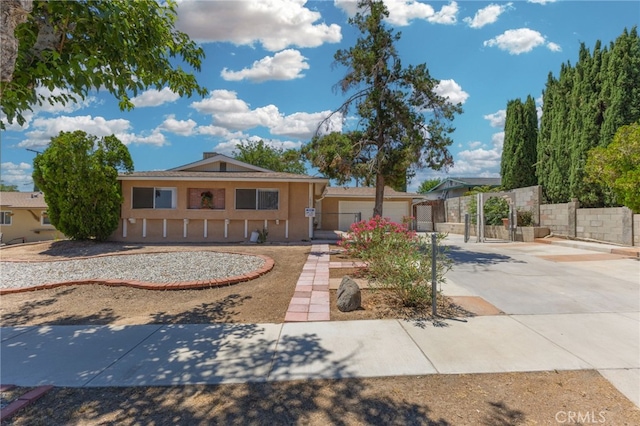 16257 Avalon Ave, Victorville, CA 92395 - view of front of home with concrete driveway, stucco siding, a garage, and a gate