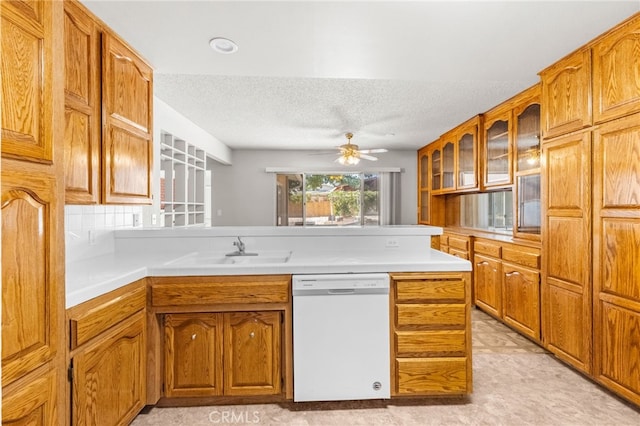 16257 Avalon Ave, Victorville, CA 92395 - kitchen with dishwasher, a peninsula, a textured ceiling, brown cabinets, and light countertops
