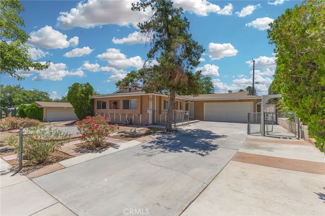16257 Avalon Ave, Victorville, CA 92395 - view of front of home with an attached garage, concrete driveway, a gate, and stucco siding